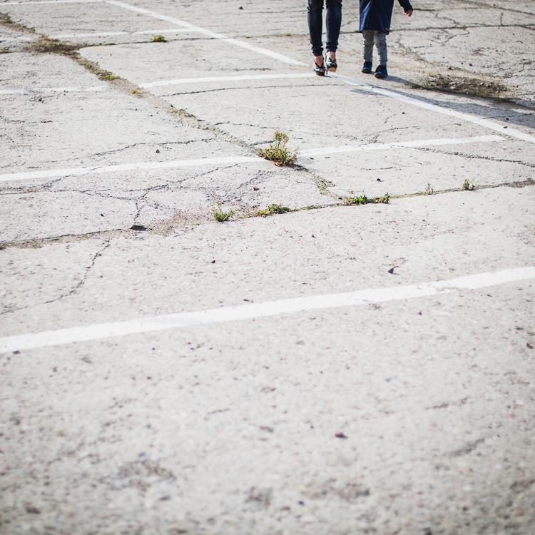 betonowa płyta parkingu po której spaceruje mama z synem