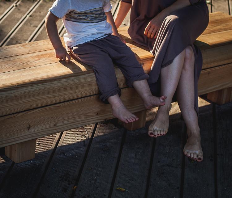 letnia stylizacja mamy i syna siedzących na ławce parkowej